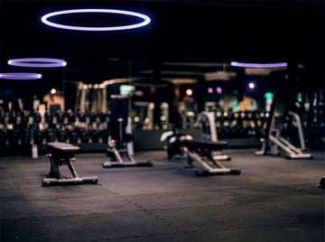 Dunkel gestalteter Krafttrainingsbereich im EASYFITNESS-Studio mit Trainingsbänken und modernen Geräten