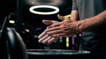 Sportler verreibt Magnesium an den Händen vor dem Krafttraining im EASYFITNESS-Studio